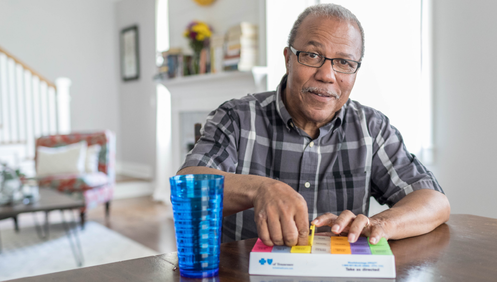 Senior man sitting at the table and taking medicine out | BCBS of Tennessee