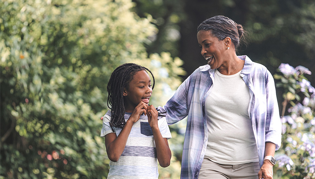 Grandmother and grand daughter having a lively conversation as they take a walk outside.